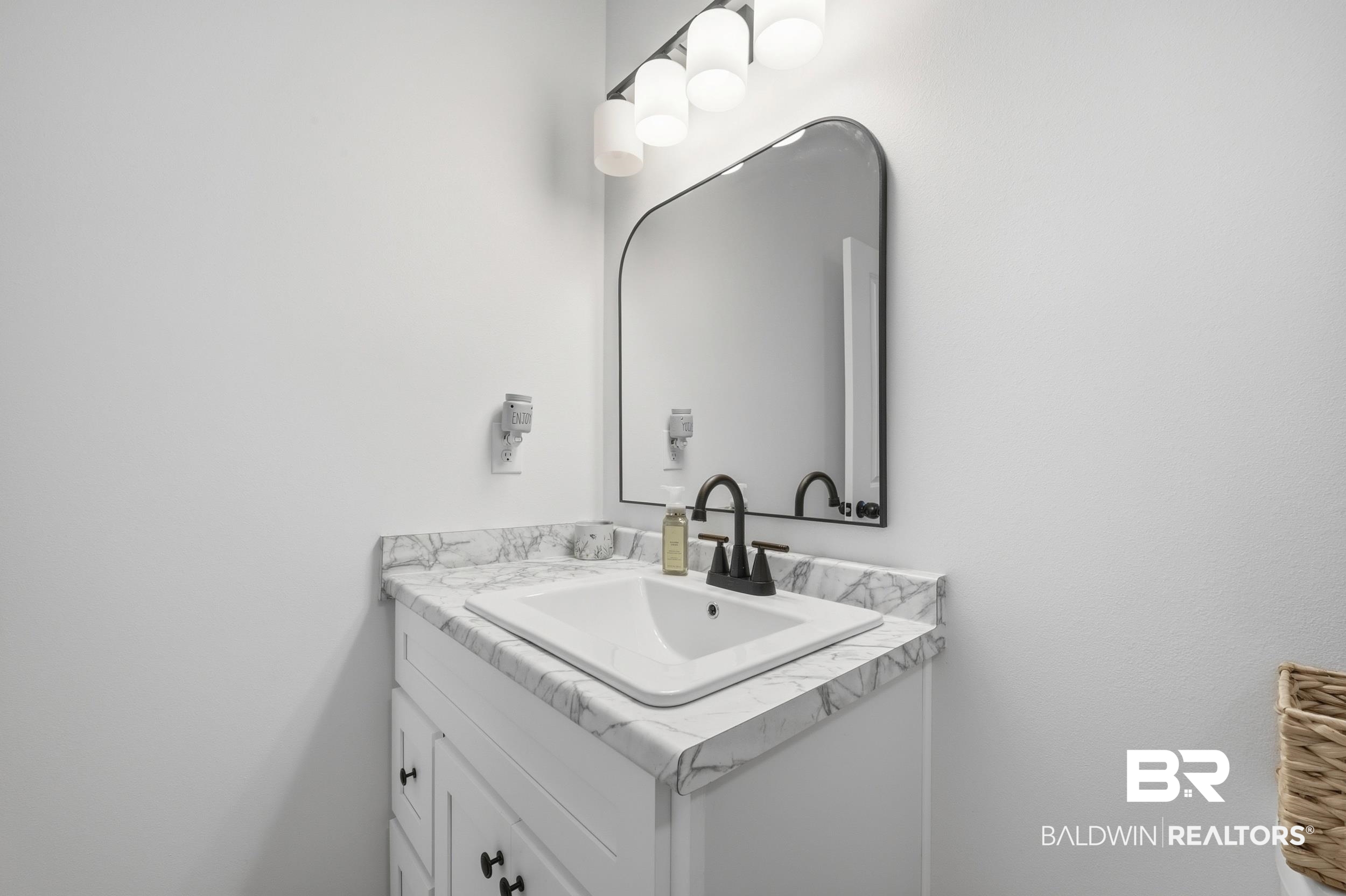 12019 Red Hill Rd Extension Bay Minette, AL 36507 - Photo 32 of 48 Bathroom vanity with a white cabinet, a white rectangular sink, a black faucet, and a patterned countertop