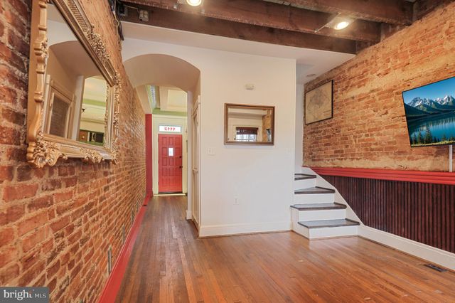 a view of a brick house with wooden floor and stairs
