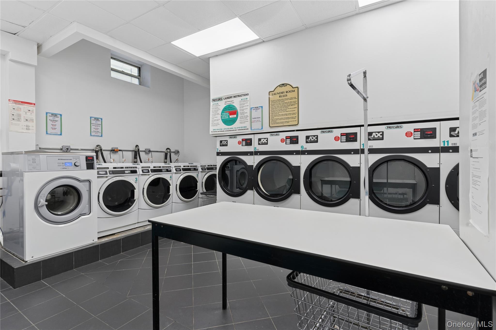 110-31 73rd Road, Unit 5N Queens, NY 11375 - Photo 11 of 13 Washroom featuring a paneled ceiling and separate washer and dryer