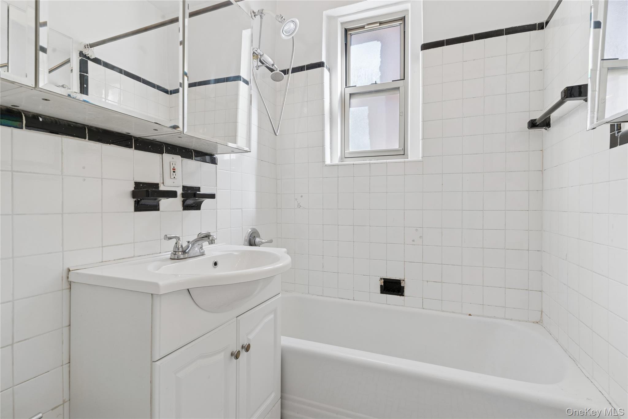 110-31 73rd Road, Unit 5N Queens, NY 11375 - Photo 10 of 13 Bathroom with vanity, shower combination, and tile walls