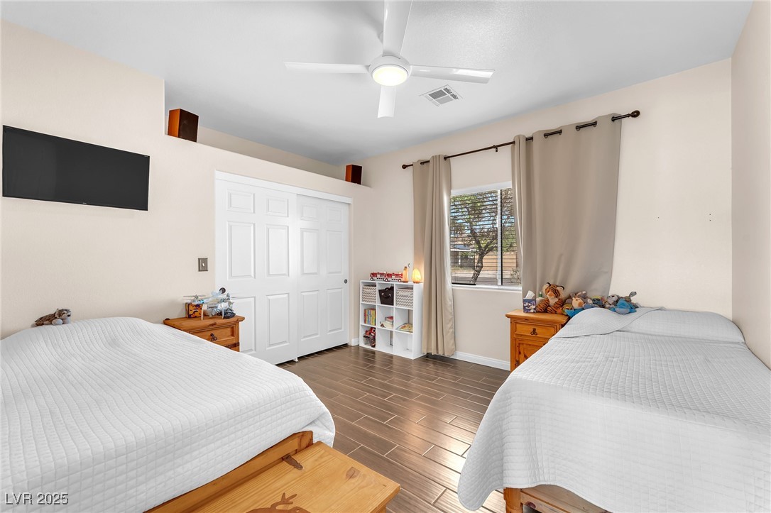 2251 Thoroughbred Road Henderson, NV 89002 - Photo 27 of 60 Bedroom with ceiling fan, a closet, visible vents, wood tiled floor, and baseboards