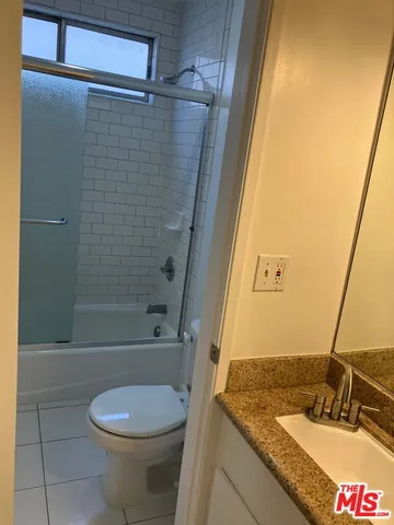 a bathroom with a granite countertop sink mirror vanity and toilet