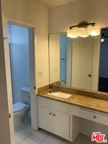 a view of an empty room with wooden floor and a chandelier fan