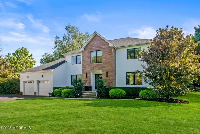 a front view of a house with a yard and trees