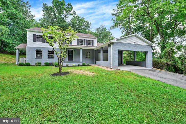 a front view of a house with a yard and trees