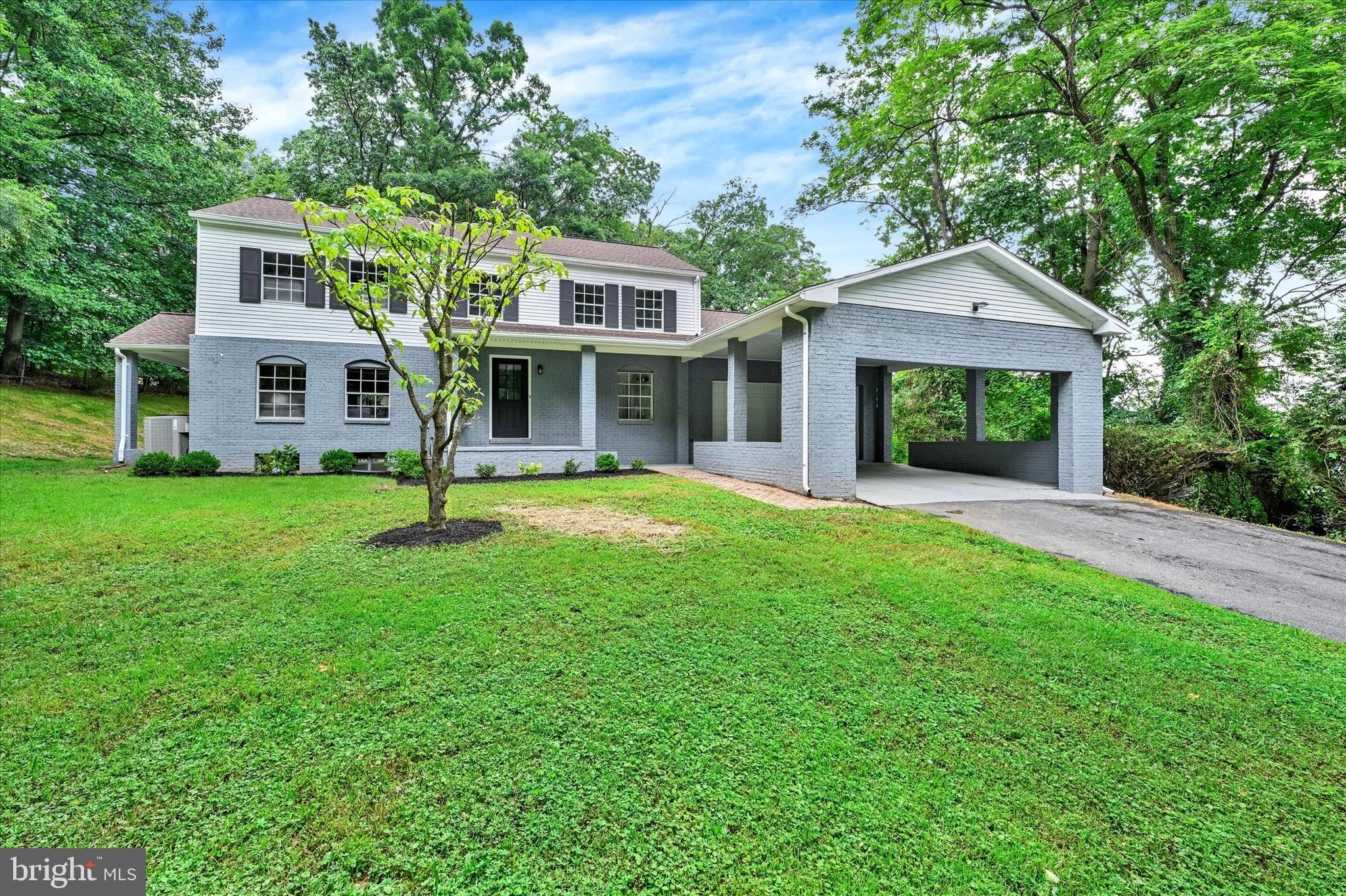 a front view of a house with a yard and trees