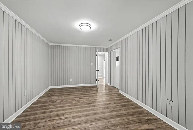 a view of an empty room with wooden floor