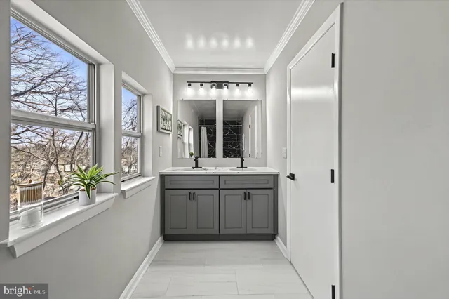 a bathroom with a granite countertop sink and a large mirror next to a window