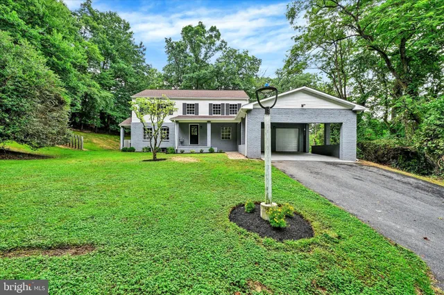 a front view of a house with a yard and green space