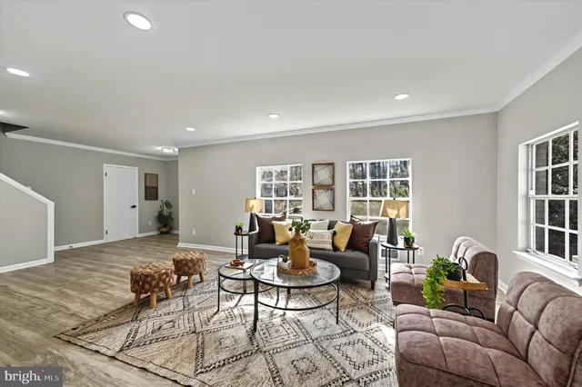 a living room with furniture and floor to ceiling windows