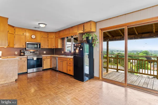 a kitchen with stainless steel appliances a refrigerator a sink a stove top oven and cabinets