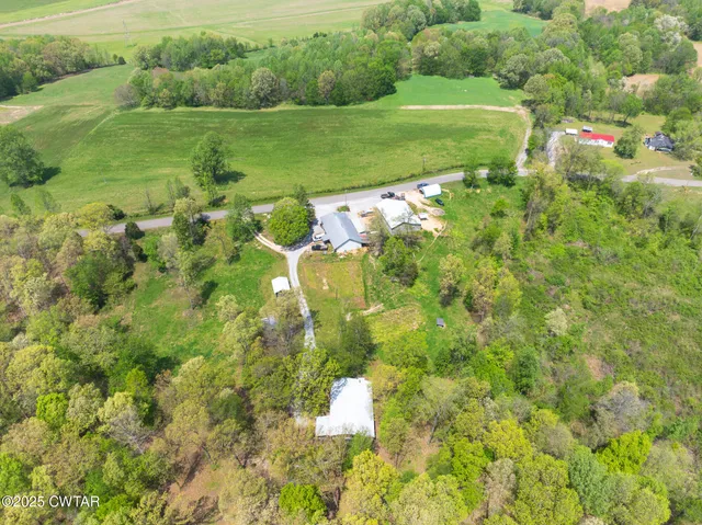 an aerial view of residential houses with outdoor space and trees