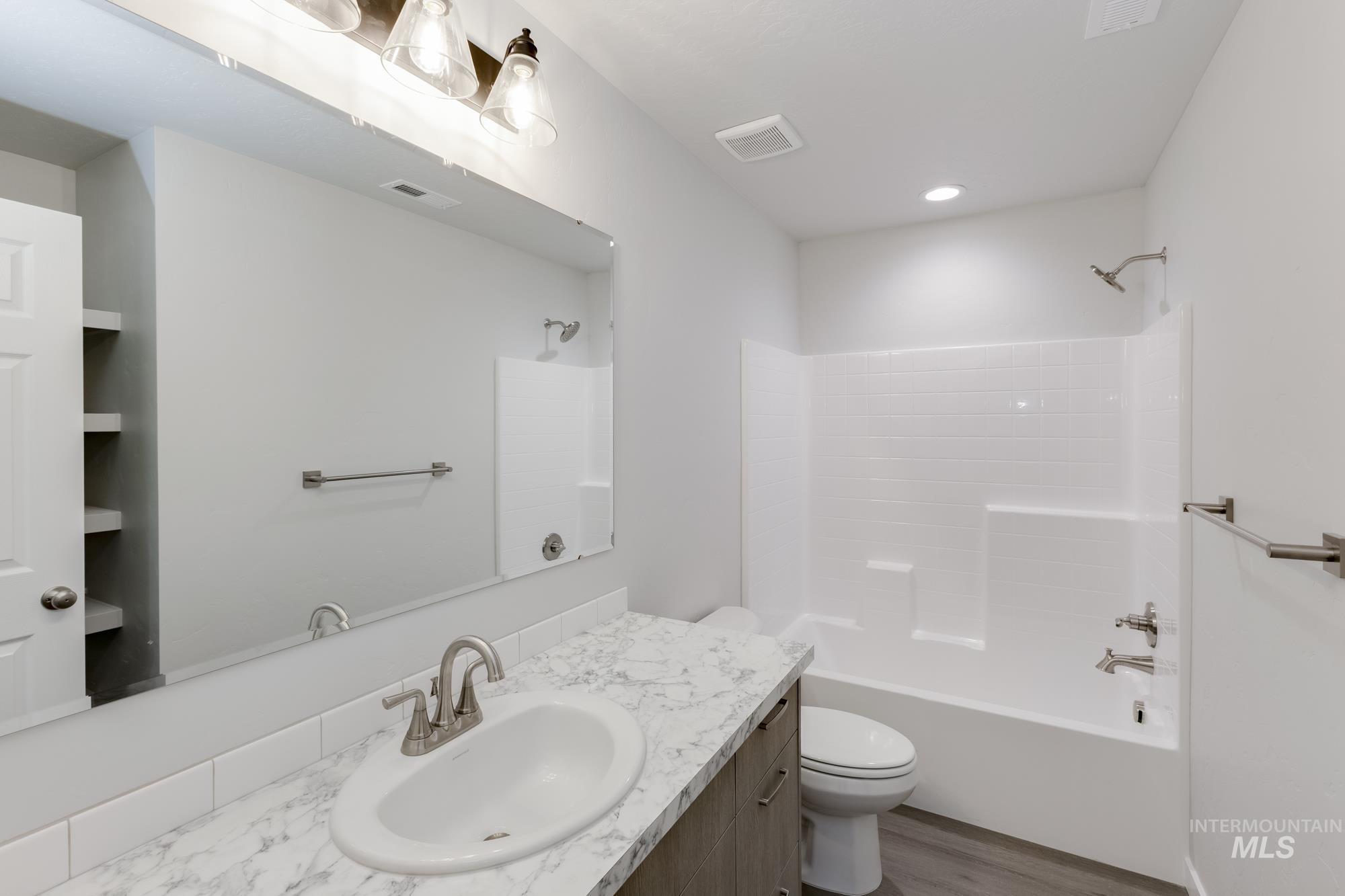 1602 Long Pond Street Middleton, ID 83644 - Photo 13 of 20 Bathroom with vanity, washtub / shower combination, light wood-type flooring, and recessed lighting