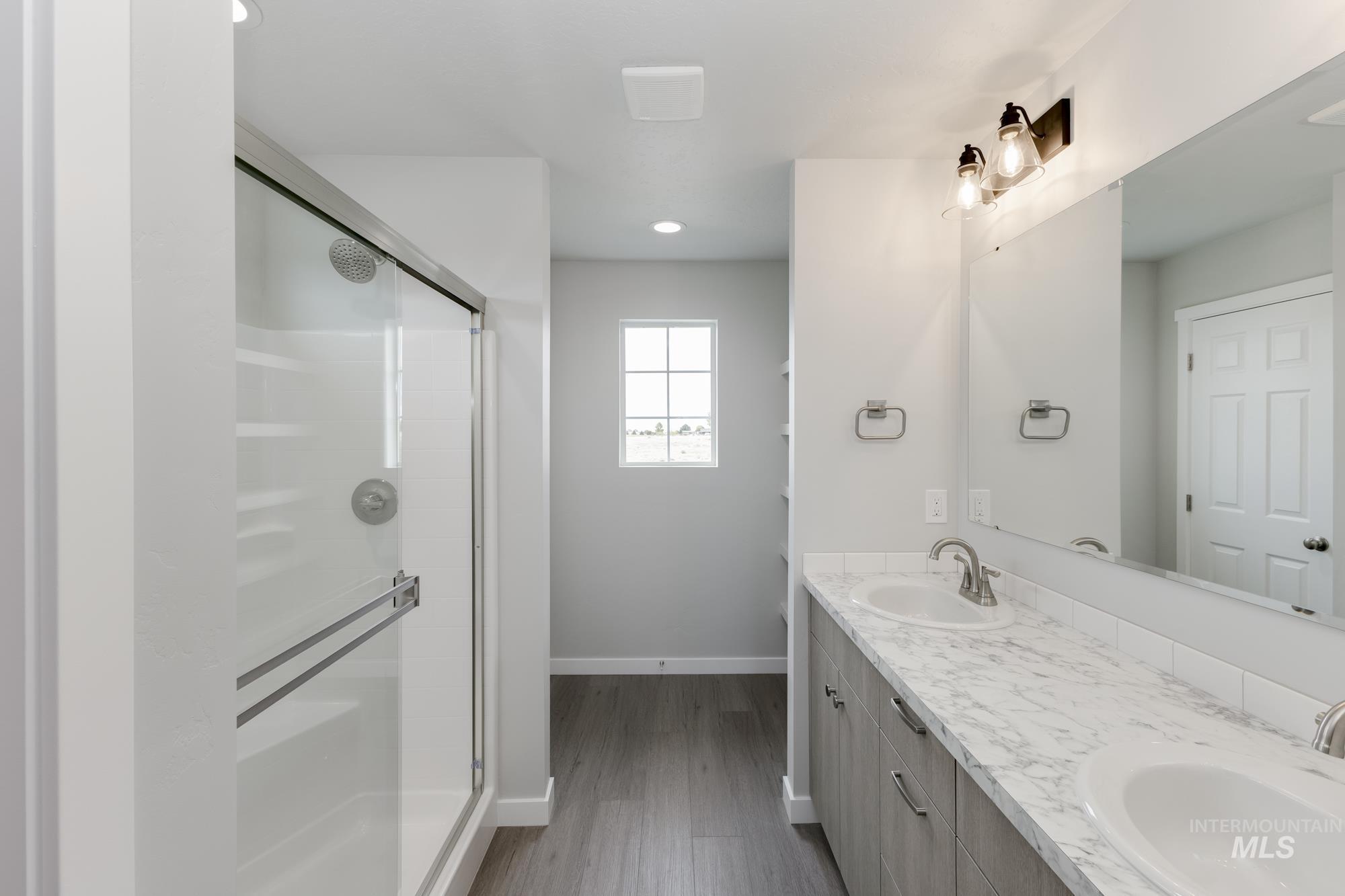 1602 Long Pond Street Middleton, ID 83644 - Photo 18 of 20 Full bathroom featuring a stall shower, double vanity, dark wood-type flooring, and recessed lighting