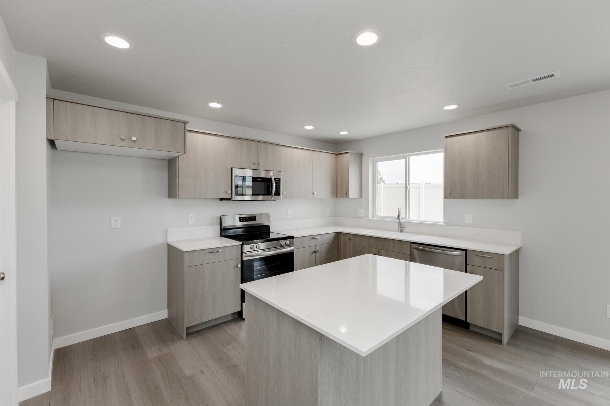 1602 Long Pond Street Middleton, ID 83644 - Photo 3 of 20 Kitchen featuring stainless steel appliances, a kitchen island, modern cabinets, light stone countertops, and light wood finished floors