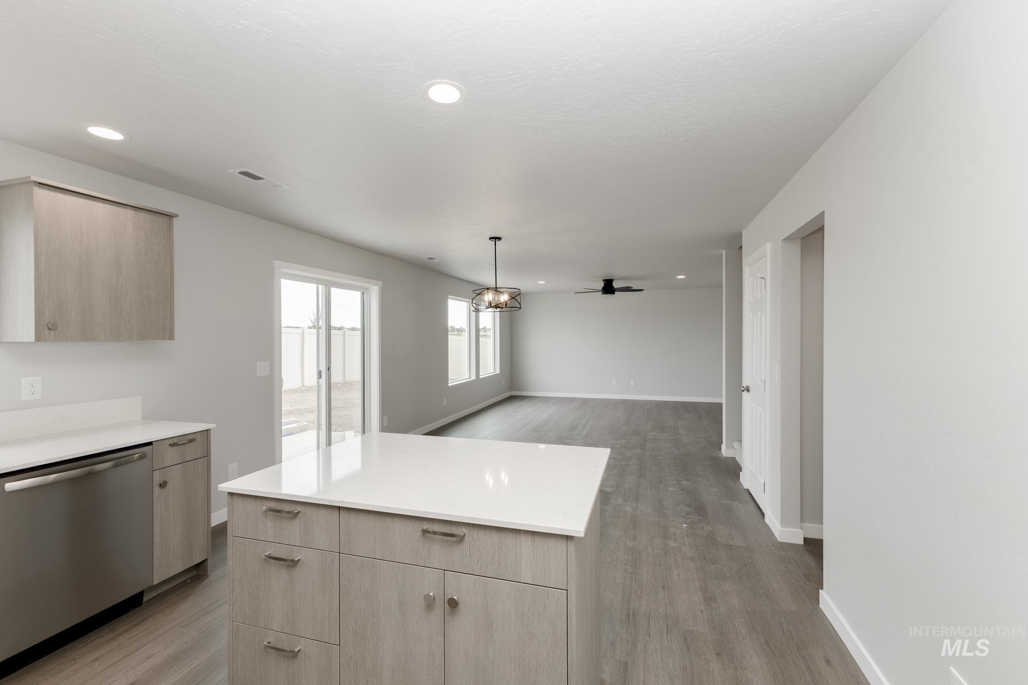 1602 Long Pond Street Middleton, ID 83644 - Photo 20 of 20 Kitchen featuring light brown cabinets, dishwasher, light wood-style flooring, open floor plan, and pendant lighting