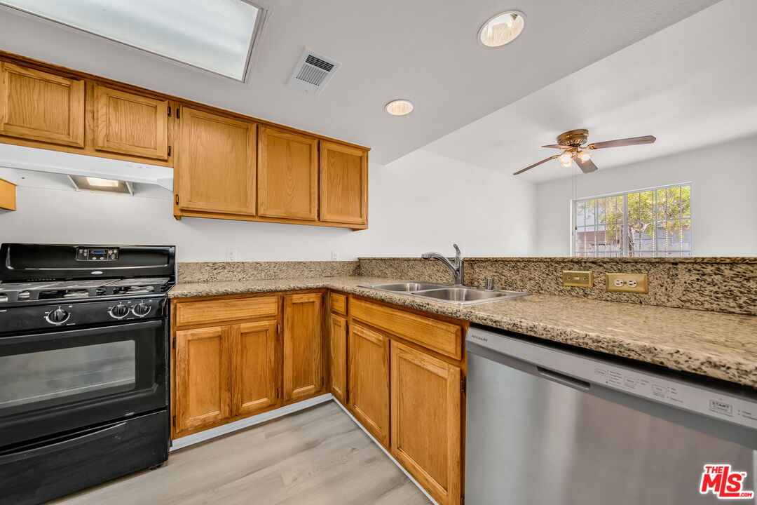 820 West Compton Boulevard, Unit 17 Compton, CA 90220 - Photo 13 of 50 a kitchen with granite countertop cabinets stainless steel appliances and a sink