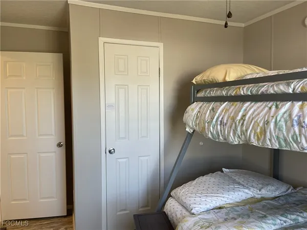 a view of a hallway with wooden floor and a bathroom