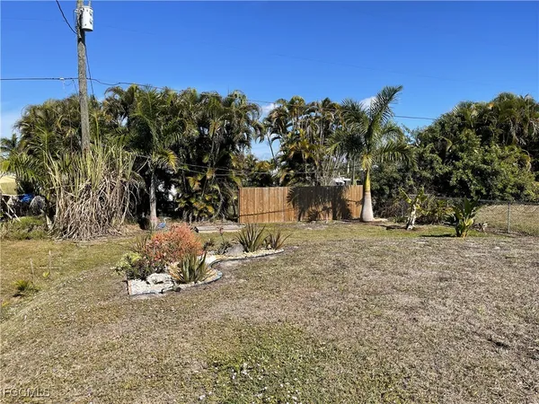 a view of a yard with wooden fence