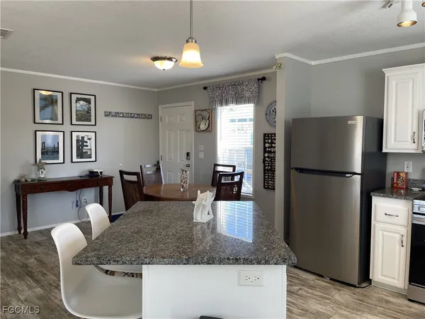 a kitchen with stainless steel appliances granite countertop a refrigerator a stove and a sink