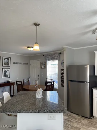 a kitchen with granite countertop a refrigerator a stove and a sink