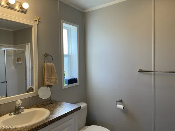 a bathroom with a granite countertop sink mirror and toilet