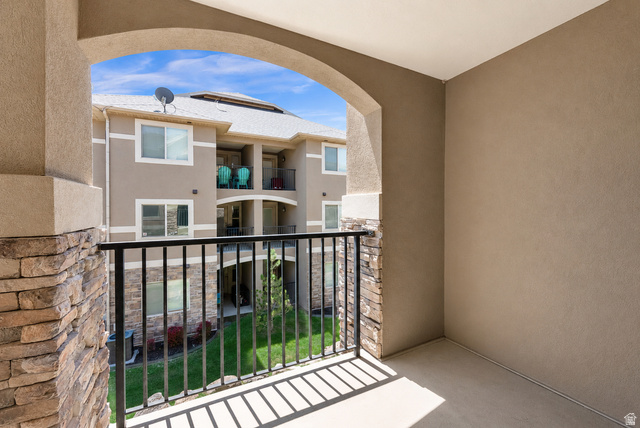 909 South Main Street, Unit G Layton, UT 84041 - Photo 10 of 25 Private balcony with stone veneer accents and a black metal railing