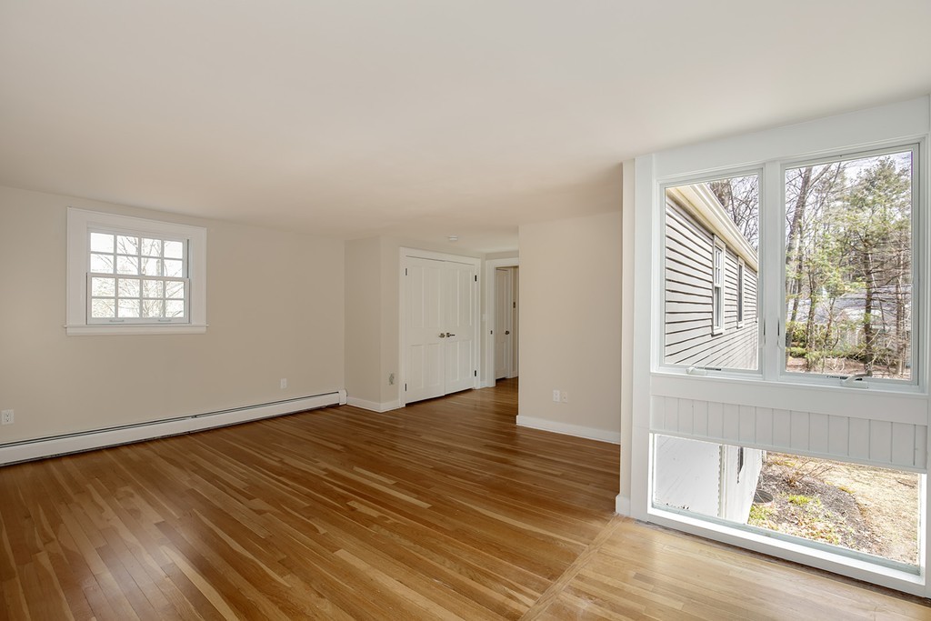 211 Pope Road Acton, MA 01742 - Photo 15 of 29 a view of an empty room with wooden floor and a window