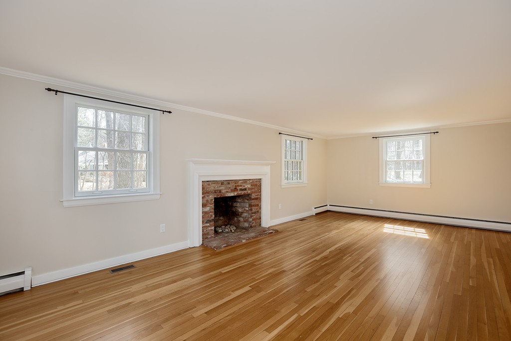211 Pope Road Acton, MA 01742 - Photo 8 of 29 an empty room with wooden floor fireplace and windows