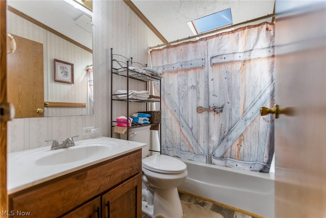 4502 Clover Road Cumberland, OH 43732 - Photo 24 of 38 Full bathroom with vanity, curtained shower, and a skylight