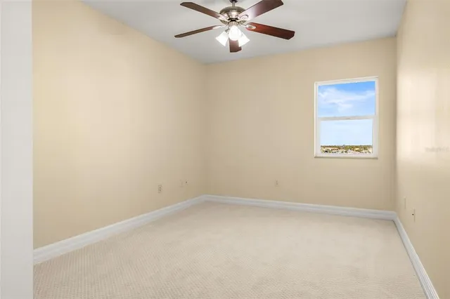 en empty room with ceiling fan and window