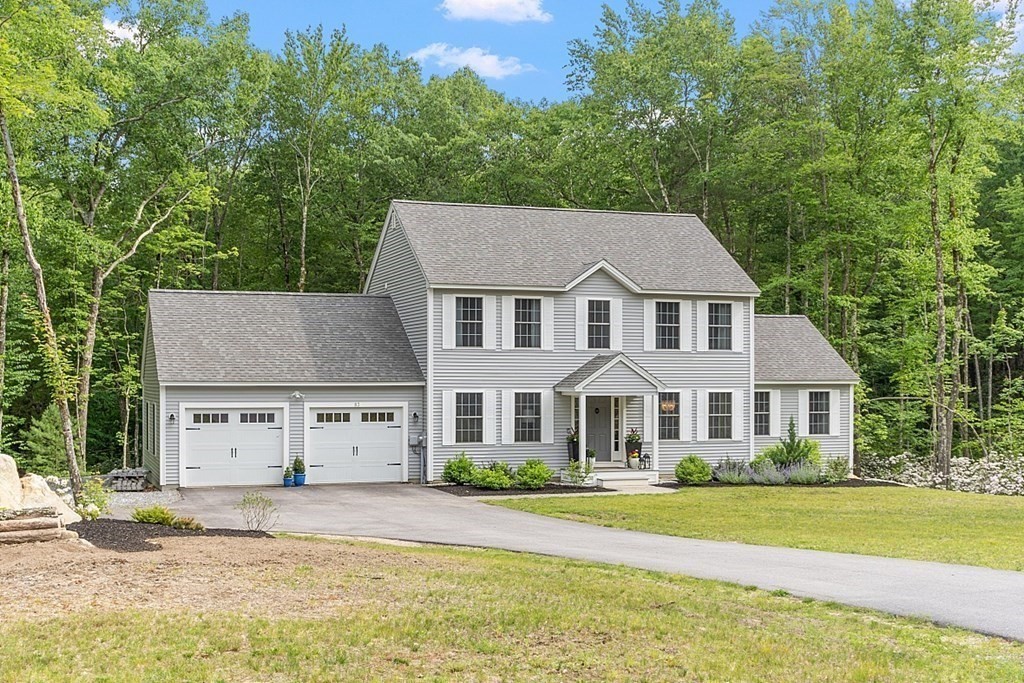 a front view of a house with a garden and yard