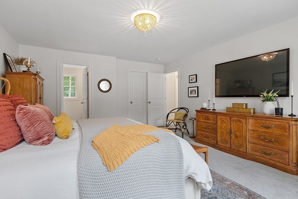 83 Russell Hill Road Brookline, NH 03033 - Photo 24 of 42 a bedroom with a bed and a flat tv screen on dresser