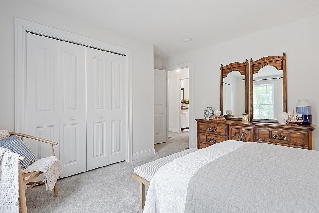 83 Russell Hill Road Brookline, NH 03033 - Photo 28 of 42 a bedroom with a bed and a large mirror with window