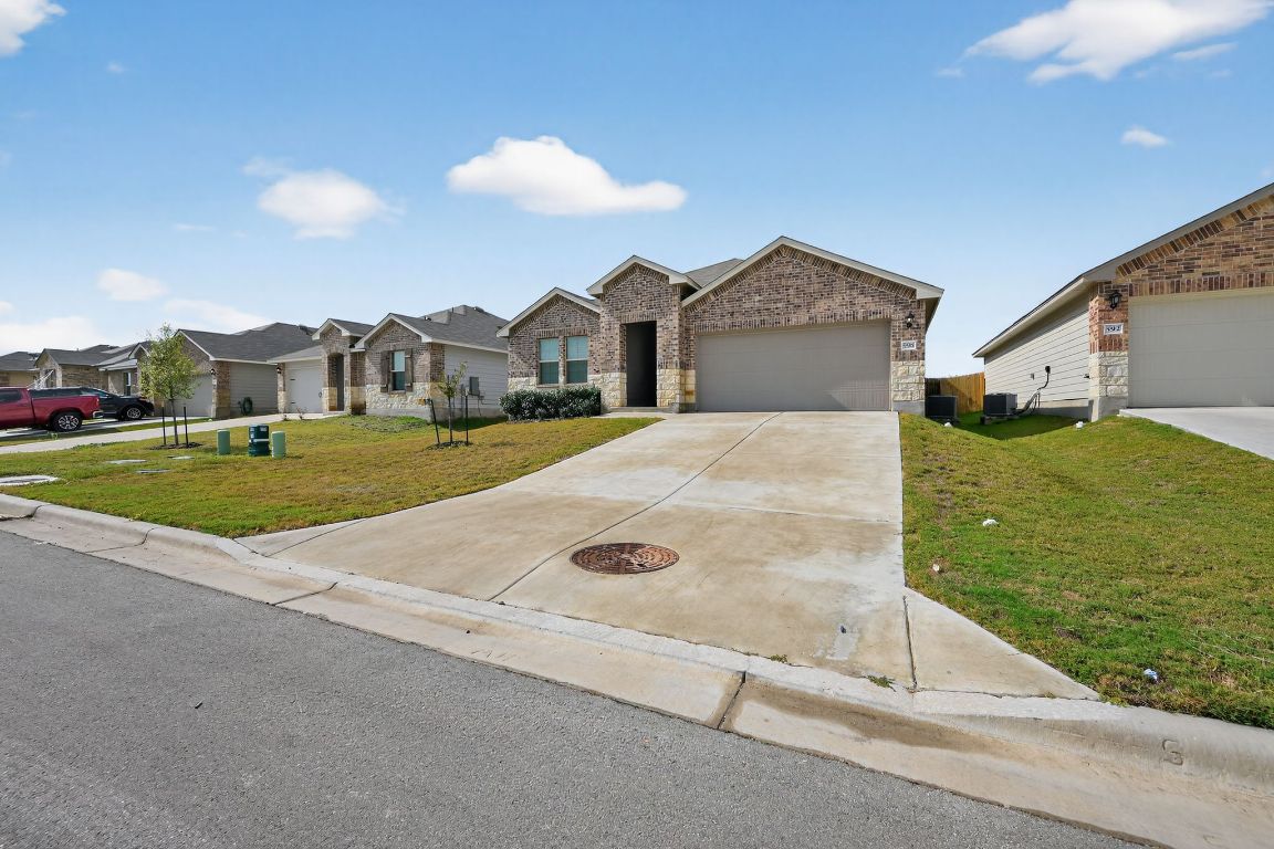 596 Wyatt Way Jarrell, TX 76537 - Photo 2 of 21 a view of a house with a yard and garage