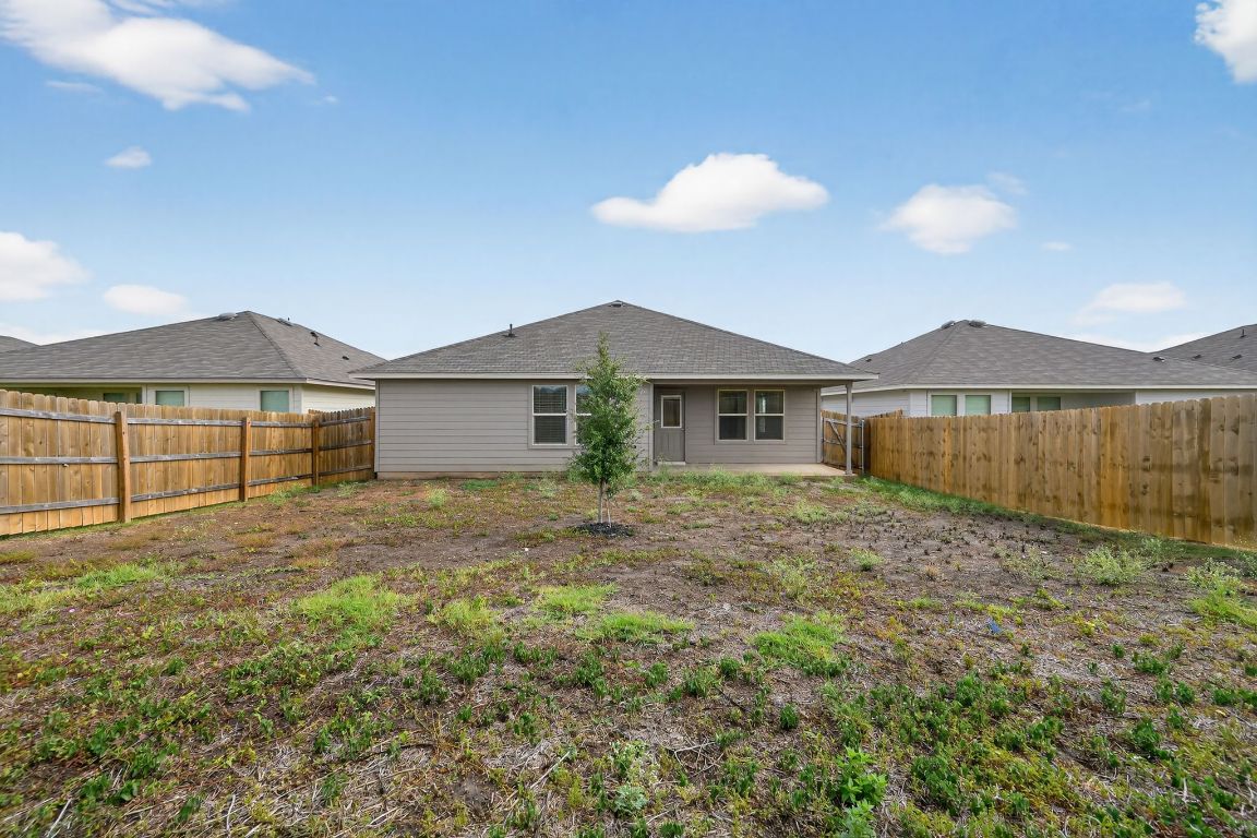 596 Wyatt Way Jarrell, TX 76537 - Photo 20 of 21 a view of a house with a backyard and a large tree