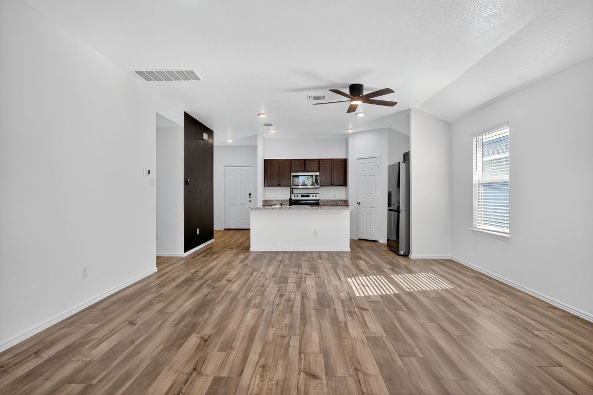 596 Wyatt Way Jarrell, TX 76537 - Photo 8 of 21 a view of a kitchen with wooden floor and a ceiling fan