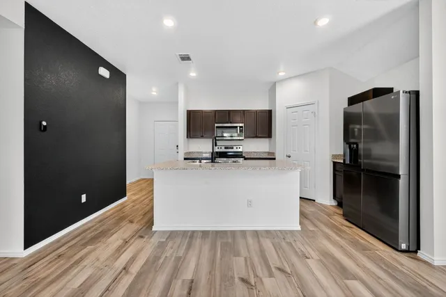 a view of a kitchen with a sink and a refrigerator