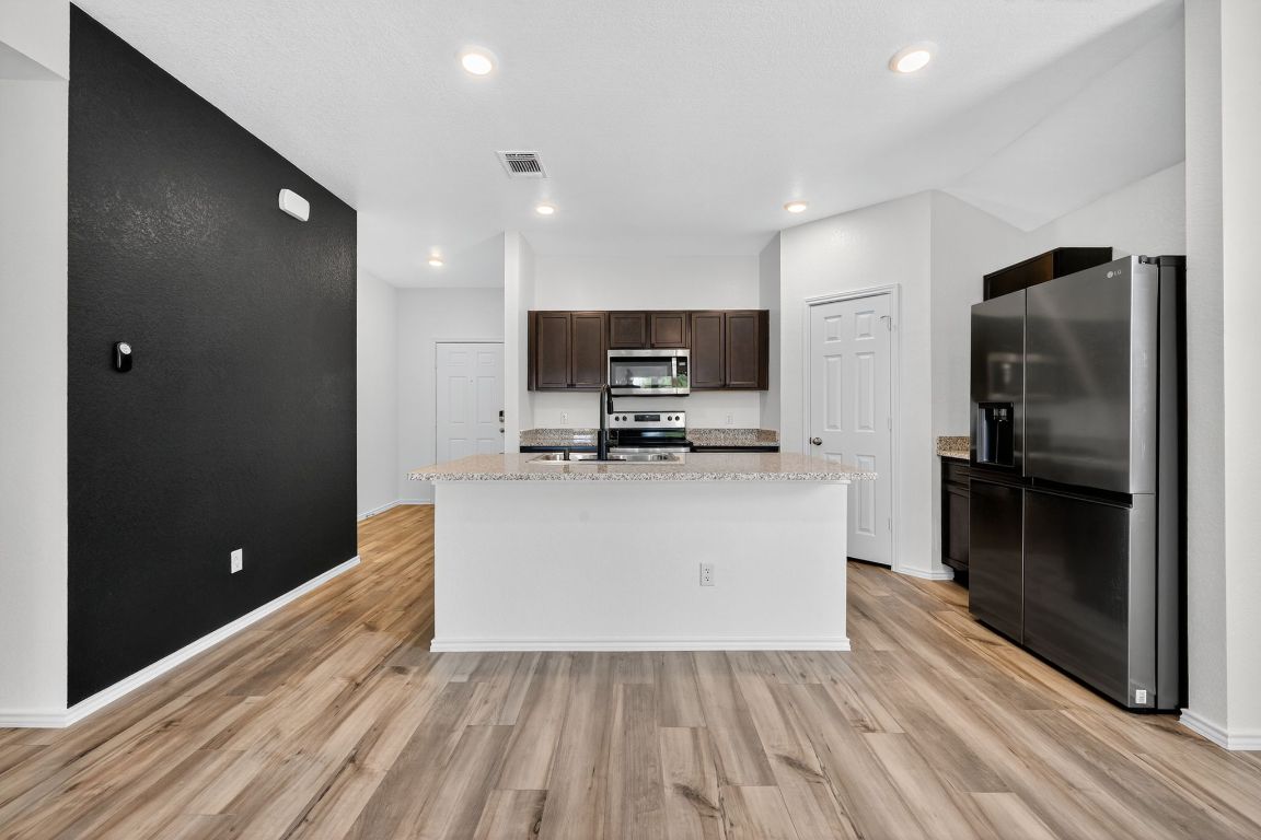 596 Wyatt Way Jarrell, TX 76537 - Photo 9 of 21 a view of a kitchen with a sink and a refrigerator