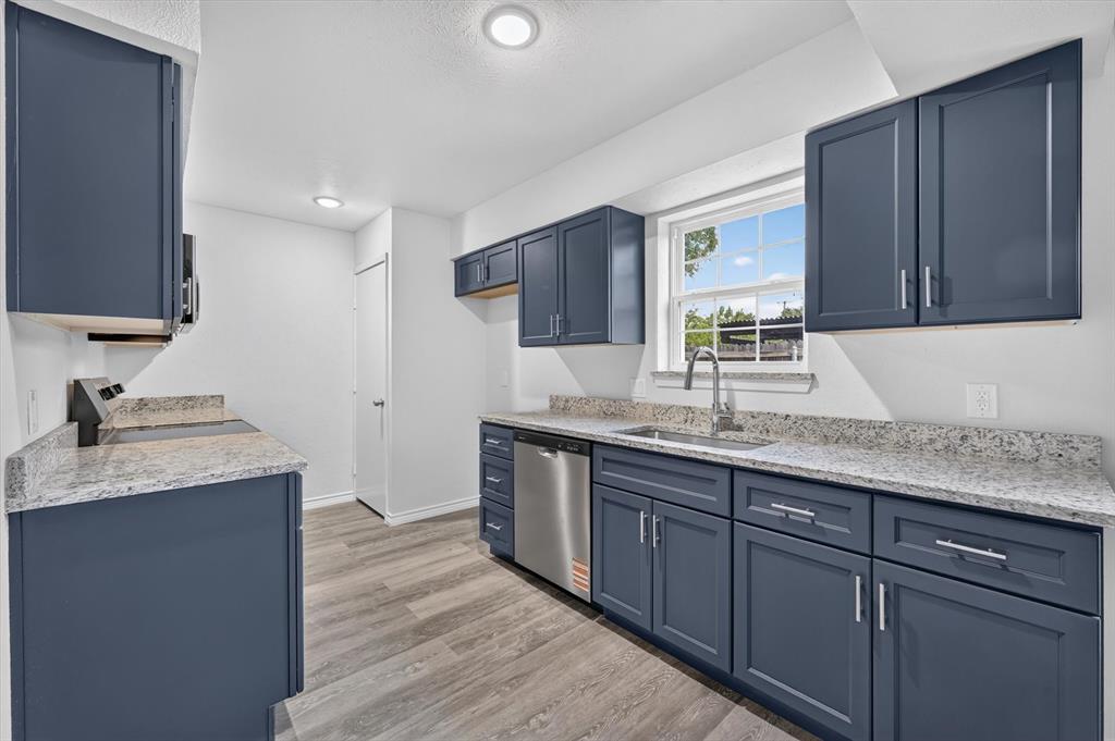 1801 East Grauwyler Road, Unit 101 Irving, TX 75061 - Photo 10 of 39 a kitchen with granite countertop a sink cabinets and wooden floor