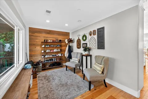 a view of a livingroom with lounge chair and windows