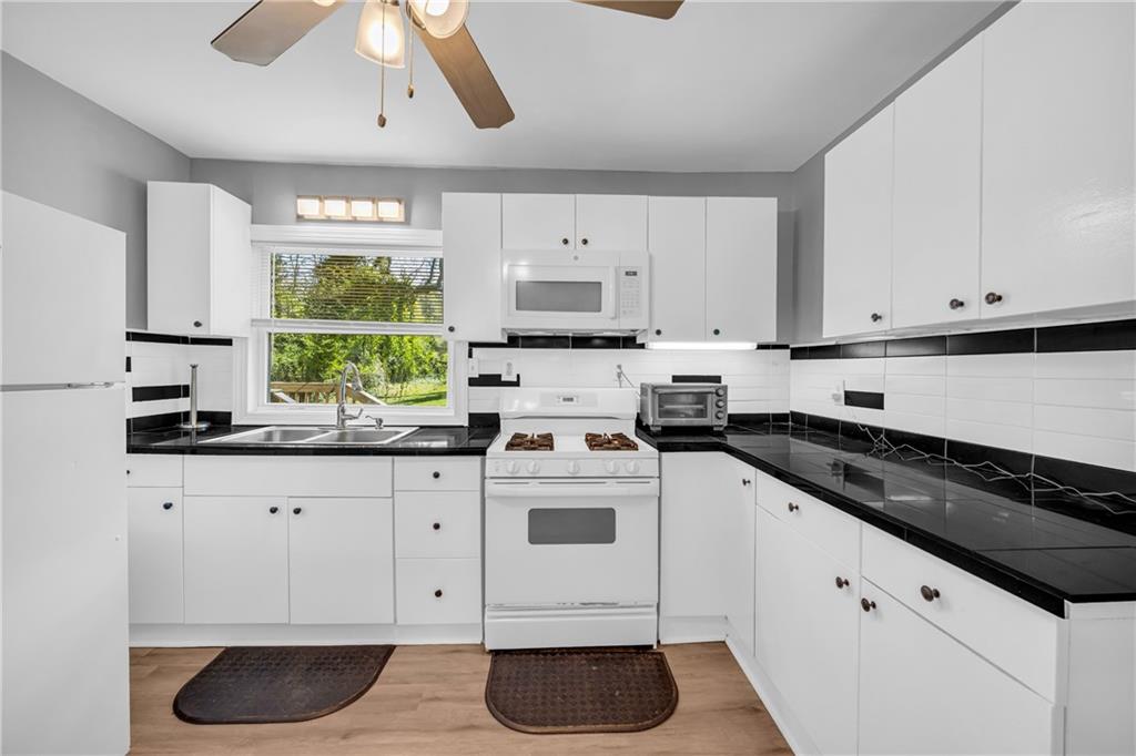 3351 Phillip Circle Decatur, GA 30032 - Photo 8 of 29 a kitchen with granite countertop white cabinets white appliances a sink and a window