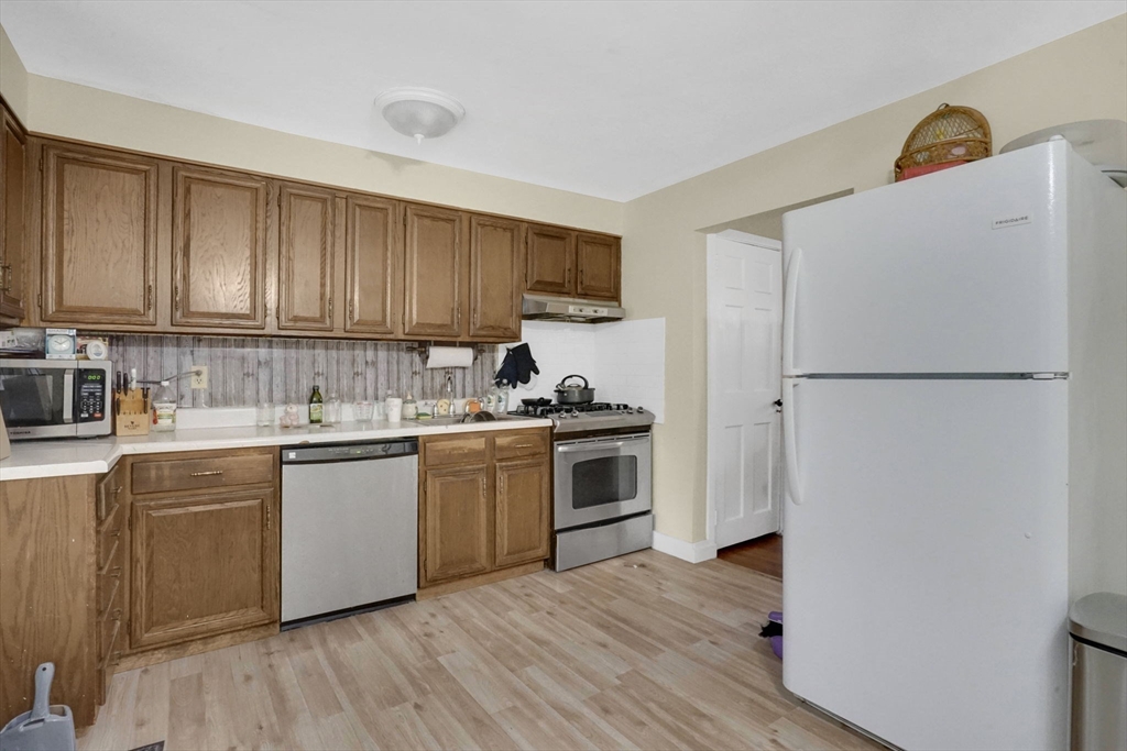 1440-1446 Carew Street Springfield, MA 01104 - Photo 17 of 26 a kitchen with a refrigerator and a stove top oven