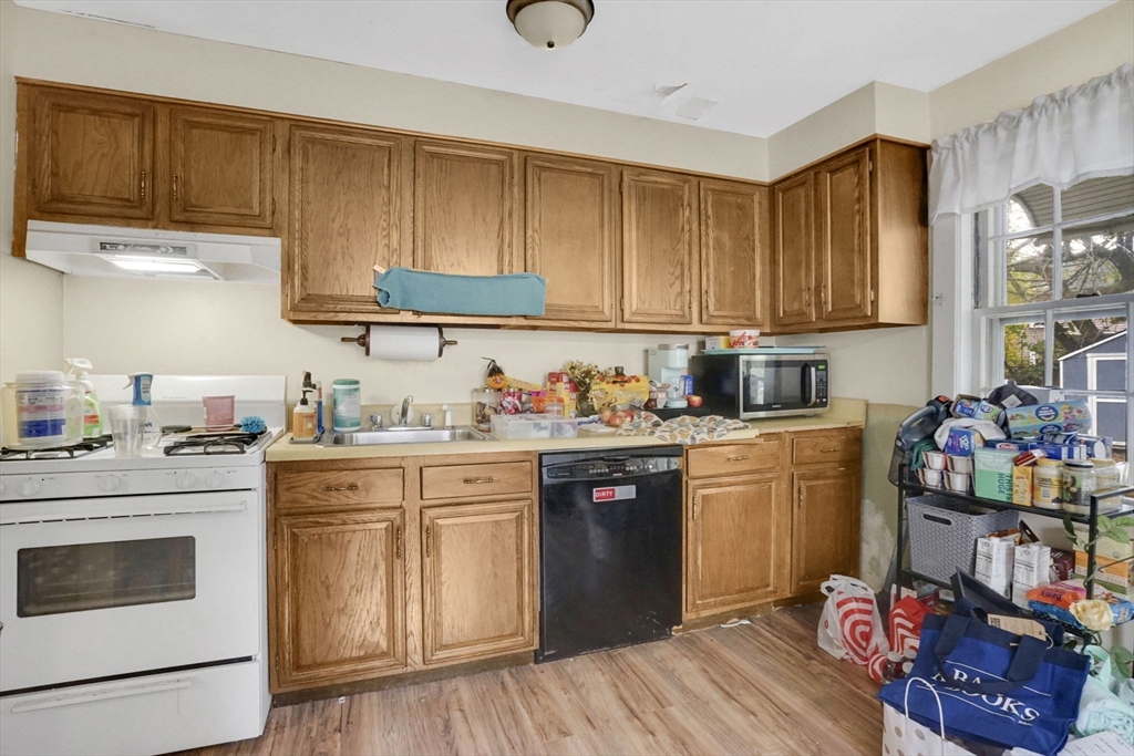 1440-1446 Carew Street Springfield, MA 01104 - Photo 20 of 26 a kitchen with granite countertop wooden cabinets and white appliances