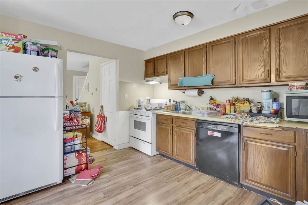 1440-1446 Carew Street Springfield, MA 01104 - Photo 21 of 26 a kitchen with a refrigerator and white wooden cabinets