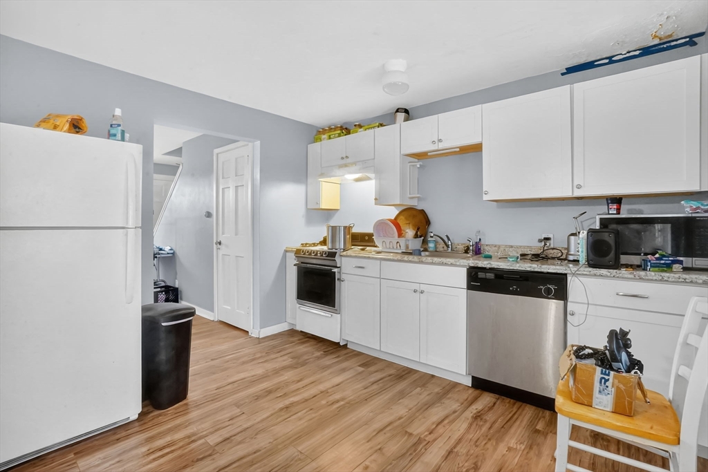 1440-1446 Carew Street Springfield, MA 01104 - Photo 6 of 26 a kitchen with a refrigerator and white cabinets
