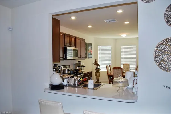 a kitchen with a sink and a flat screen tv