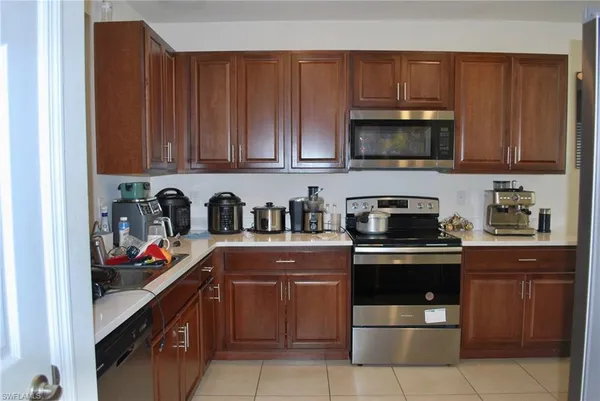 a kitchen with stainless steel appliances granite countertop wooden cabinets a stove top oven a sink and dishwasher