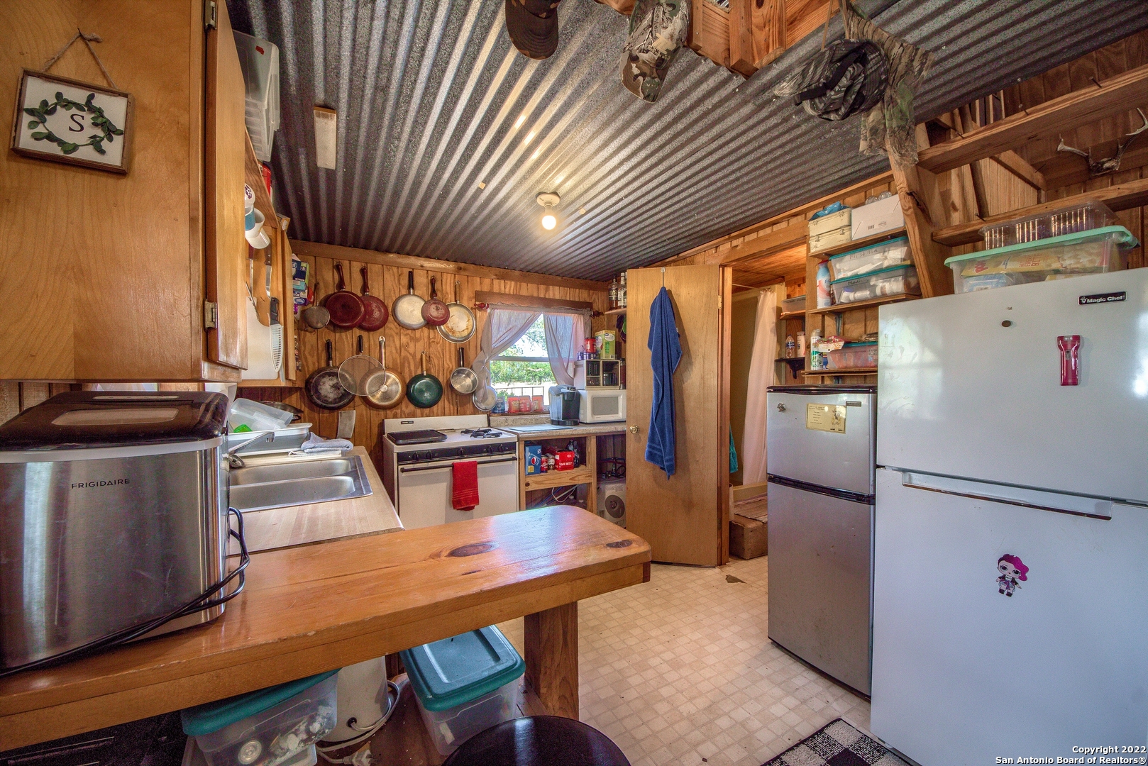 465 Watkins Road Mountain Home, TX 78058 - Photo 16 of 56 a kitchen with stainless steel appliances granite countertop a refrigerator a sink dishwasher a stove a dining table and chairs with wooden floor