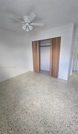 a view of an empty room with a chandelier fan